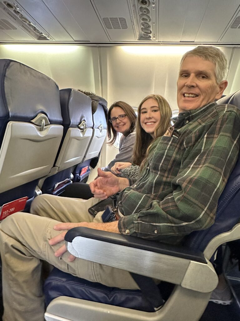 three people sitting on a plane going to New England