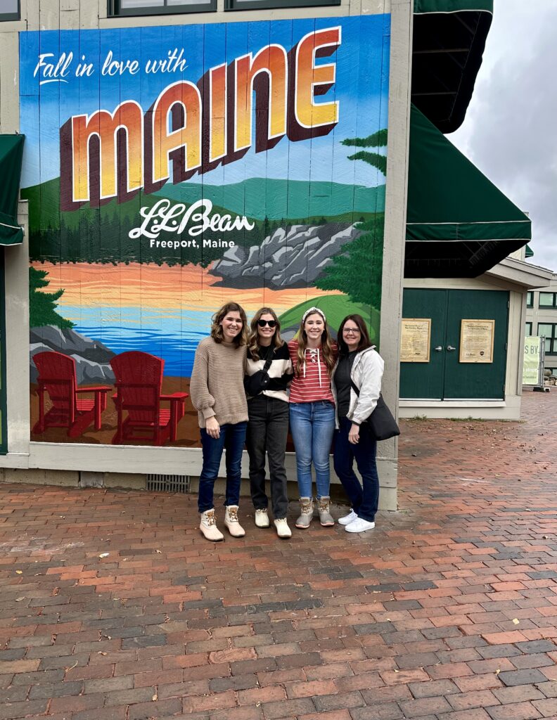 four girls in front of Maine mural outside of LL Bean