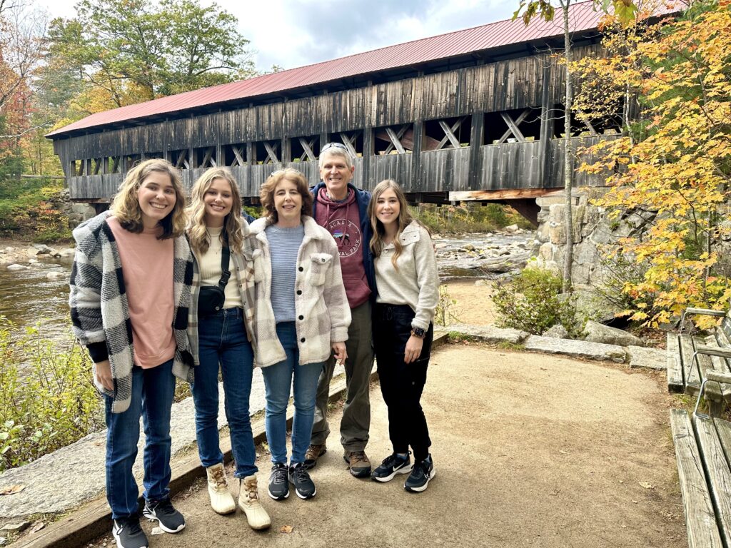 family standing in front of albany covered bridge in New Hampshire