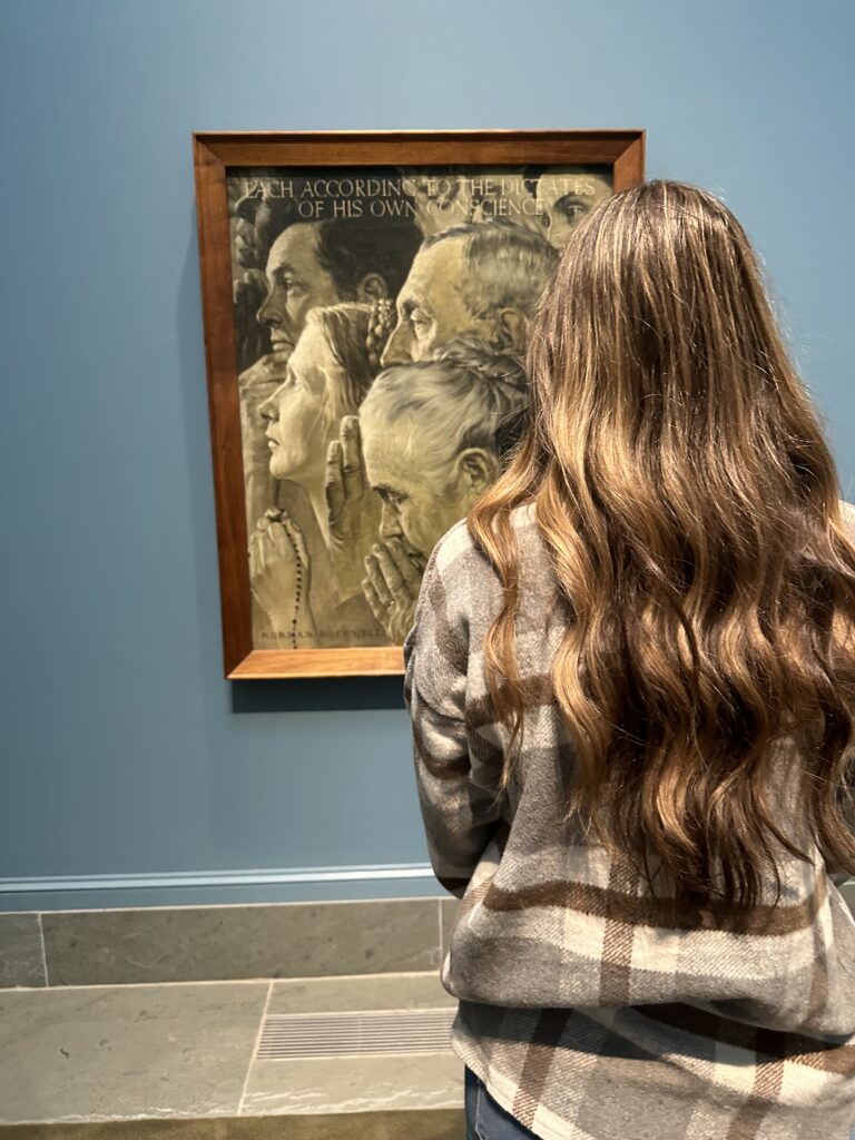 Madelyn Victoria standing in front of Norman Rockwell painting, Freedom of Worship