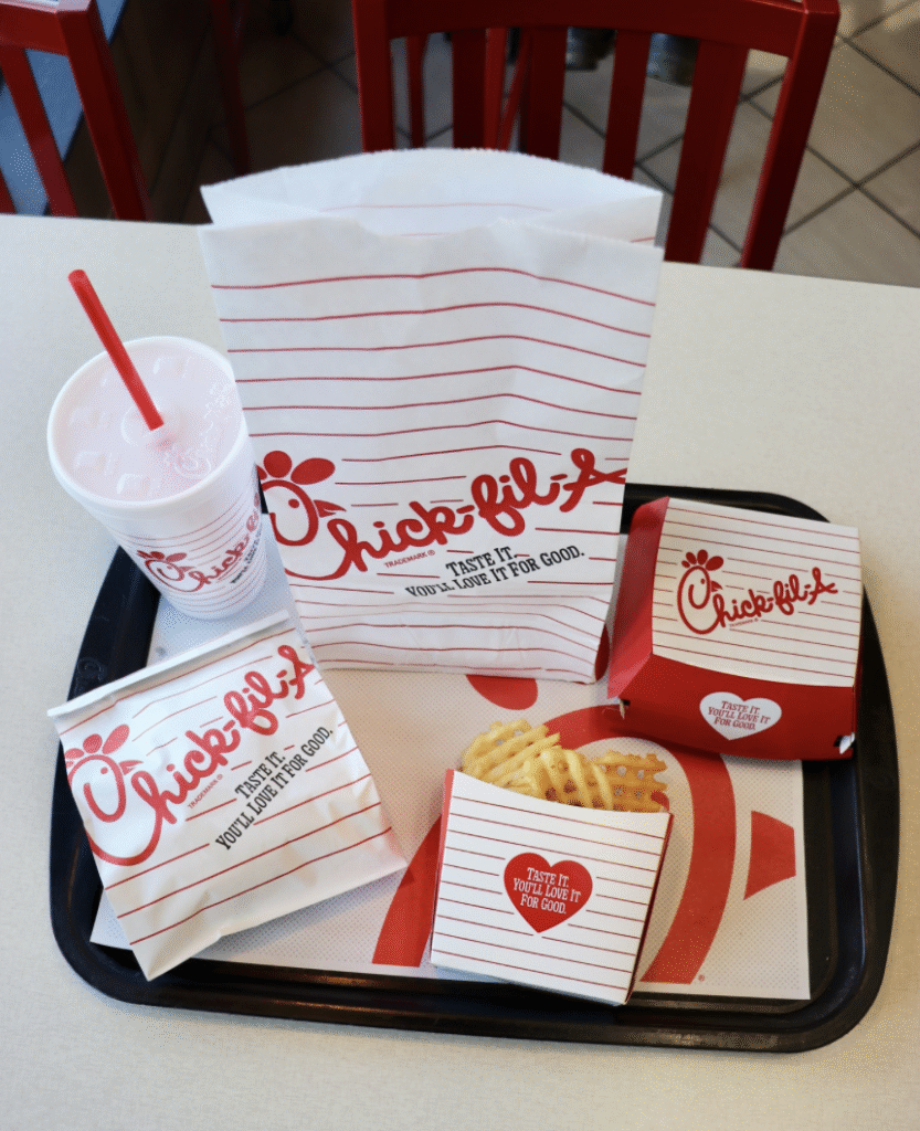 Chick-fil-A tray with fries, drink, chicken nuggets package, and chicken sandwich package in retro packaging for their Newstalgia campaign
