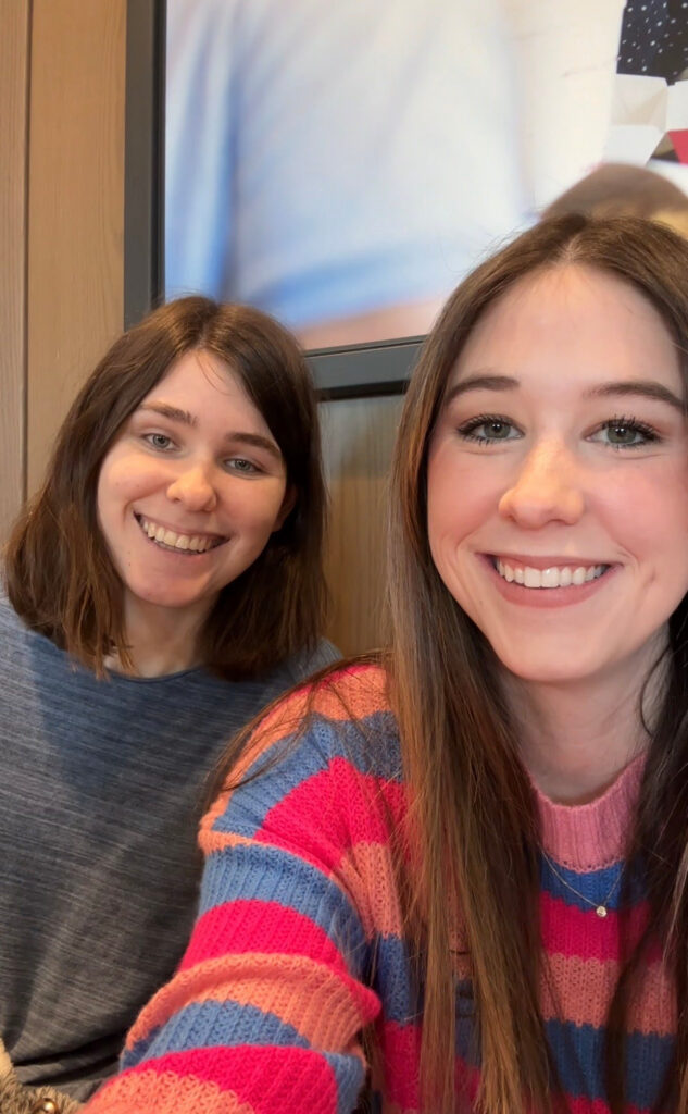 two young adult girls taking a selfie at Chick-fil-A discussing successful marketing campaigns by major brands